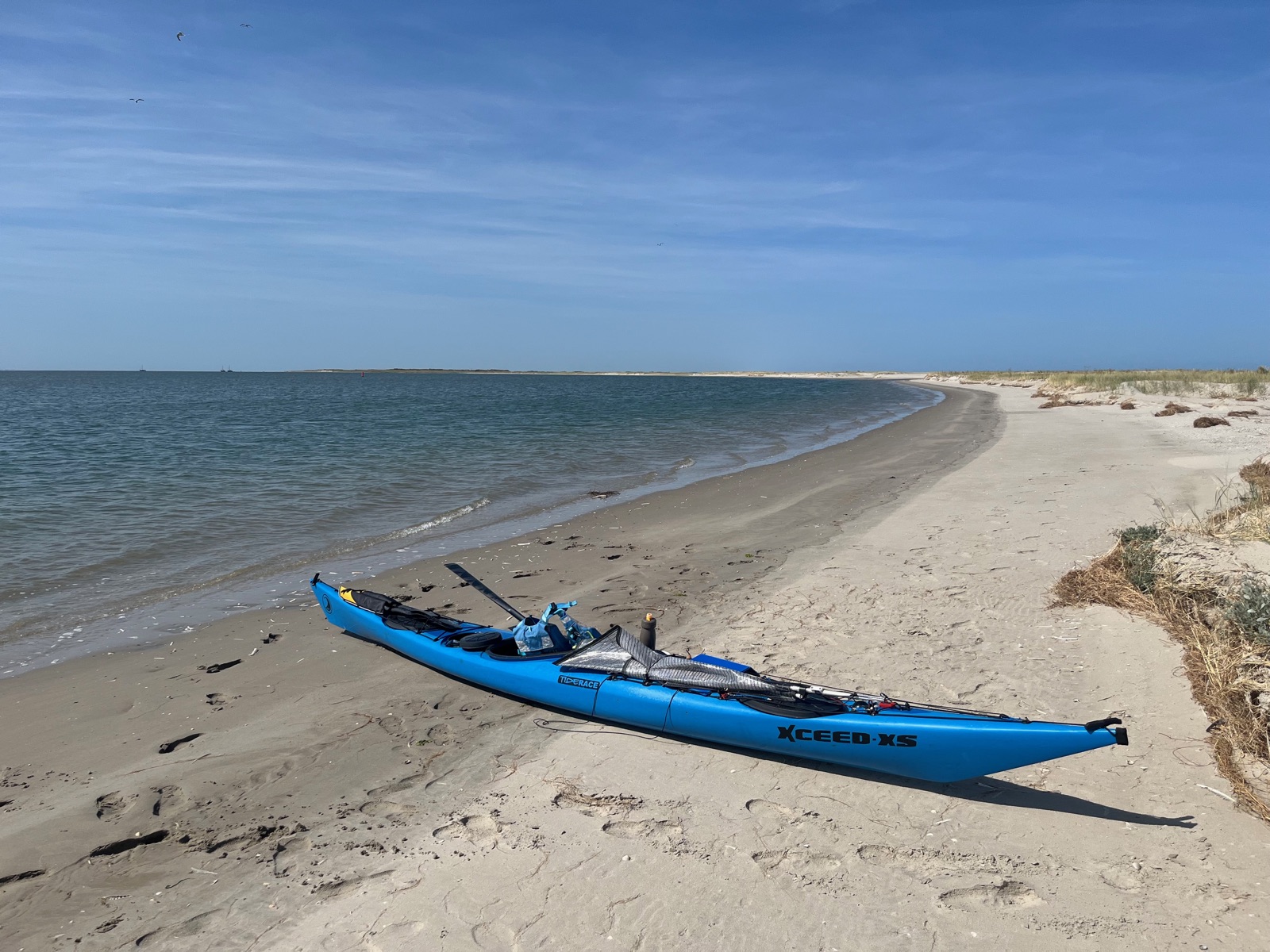 A blue sea kayak pulled up on a sandy beach on Schiermonnikoog